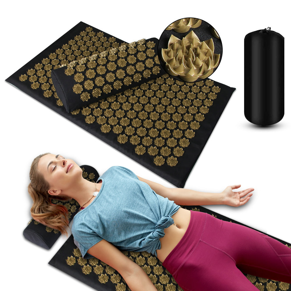 Acupressure mat with gold needles, a pillow, and a pump on a white background